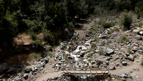 Aerial-view-of-a-crane-shot-of-a-bridge-over-a-river-dry-and-full-of-rocks-due-to-climate-change