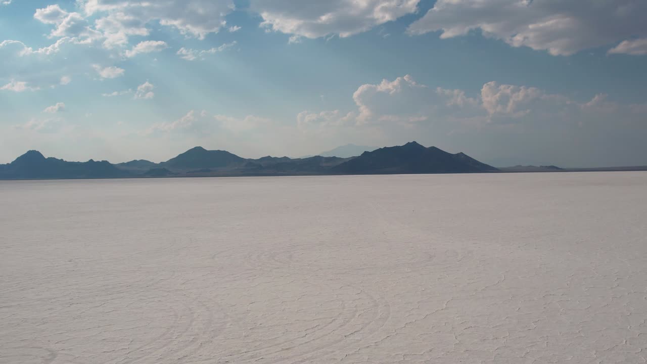 salinas de bonneville en utah, estados unidos, vasta tierra blanca salvaje cubierta de sal y minerales, visitantes turistas caminando en formación natural del desierto con montañas en el horizonte