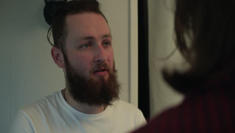 a bearded man gazes softly toward another figure, their interaction filled with warmth and understanding. a comforting hand on his shoulder signals connection, reassurance, and support.