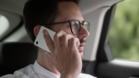 Passenger-talking-by-mobile-phone-in-a-taxi