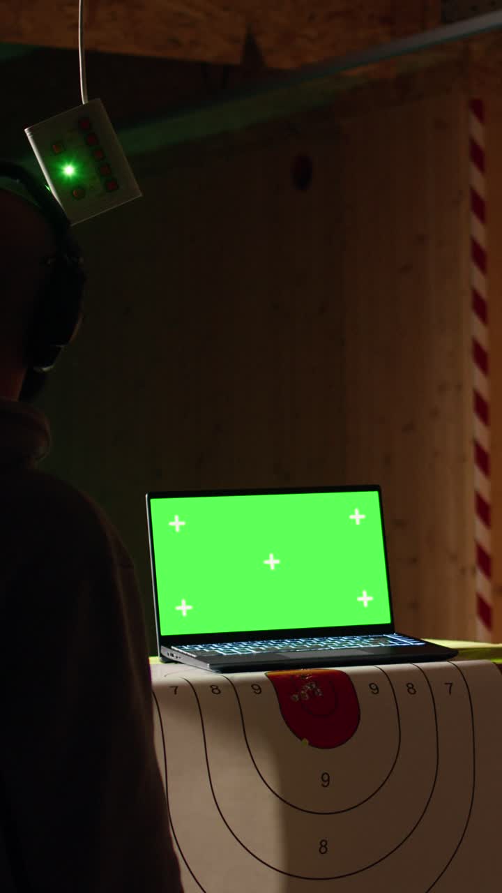 Vertical video Mockup laptop and shooting gallery safety officer watching client shoot targets
