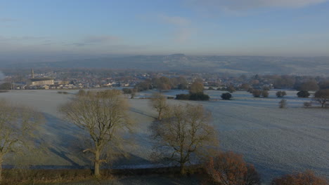 Aumento-Del-Establecimiento-De-Drones-Aéreos-Disparados-Sobre-Campos-Helados-Con-La-Aldea-De-Calverley-En-El-Fondo-Leeds,-West-Yorkshire,-Reino-Unido