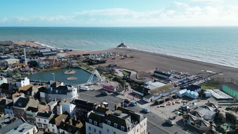 tomada aérea de un avión no tripulado de hastings, reino unido, volando sobre la ciudad de la playa, el parque de atracciones y la flota de pesca terrestre