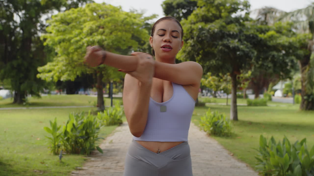 Latin Woman Stretching Arm and Body Muscles Outdoors