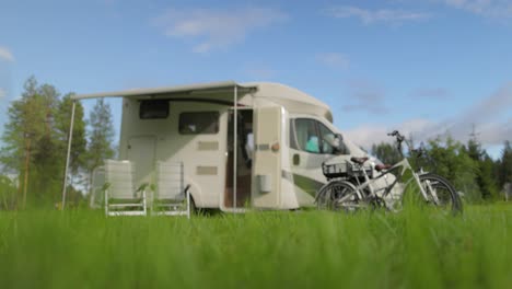 family vacation travel rv, holiday trip in motorhome, caravan car vacation. warning, the focus is in the foreground of the grass, the background is blurred, the car is out of focus.