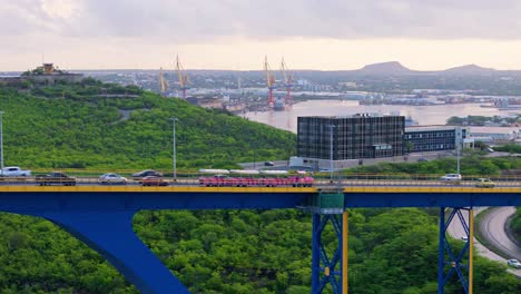 pink tourist train or trolley crosses on juliana bridge, willemstad curacao