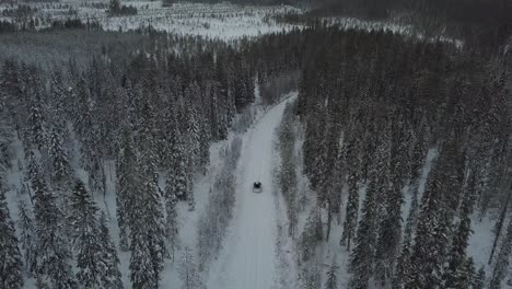 Cars-driving-through-a-snow-covered-landscape-near-Kuusamo,-Finland