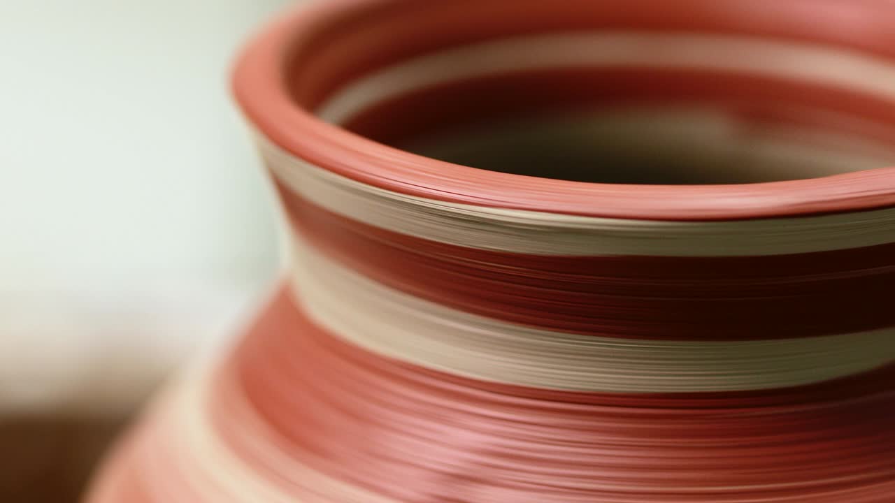 olla pintada girando en la rueda de cerámica. sólo pintado con pincel