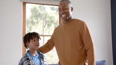 Portrait-of-happy-african-american-father-and-son-embracing-at-home,-slow-motion