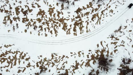 Vista-Aérea-De-Arriba-Hacia-Abajo-De-Un-Vehículo-Todo-Terreno-A-La-Deriva-En-Una-Esquina-En-Un-Sendero-De-Río-Congelado