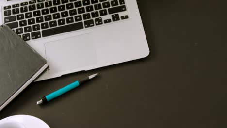 Laptop,-flora,-organizer,-coffee-and-pen-on-black-background-4k