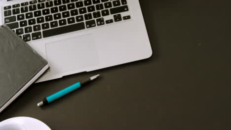 Laptop, flora, organizer, coffee and pen on black background 4k