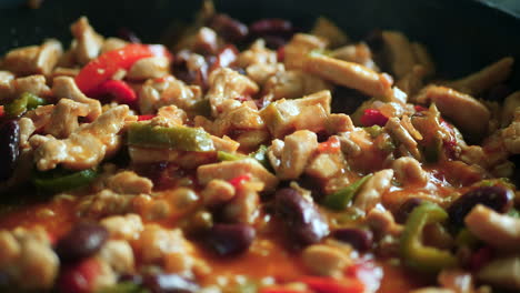 Pull-back-shot-of-filling-for-homemade-fajitas-cooking-with-chicken,-peppers-and-onions