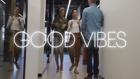 good vibes text animation over people walking and talking in office hallway