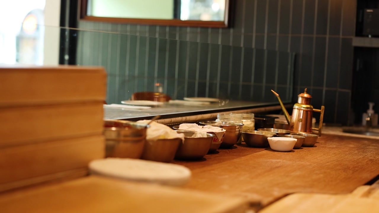 Static shot of an organized Italian kitchen counter with cooking ingredients and metal prep bowls.
