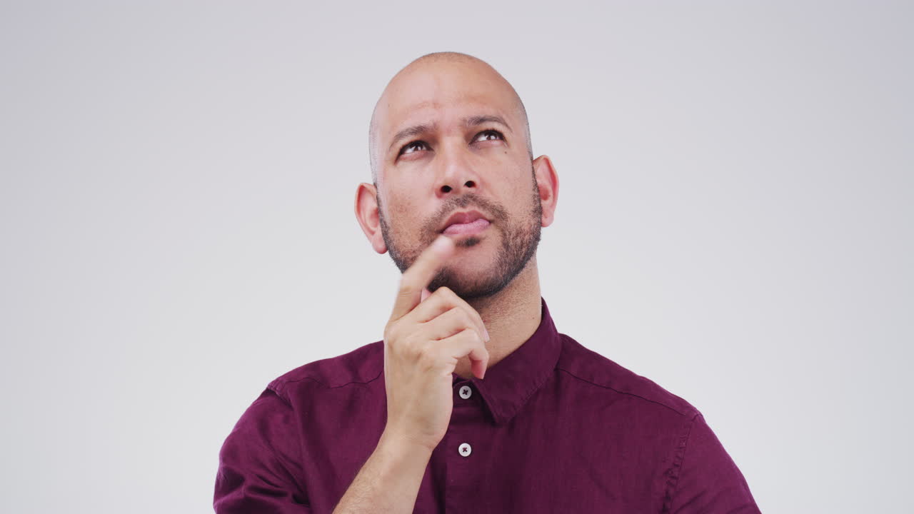 un joven que se ve reflexivo contra un gris