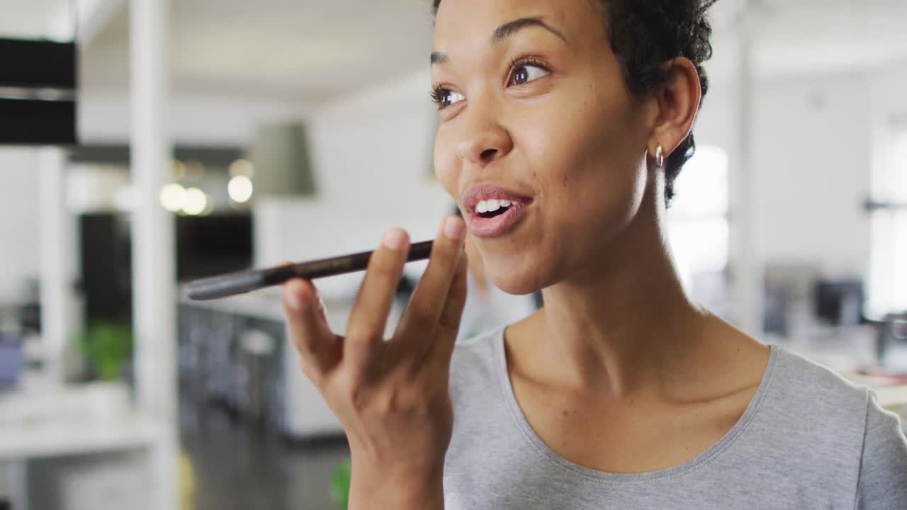 Portrait of happy biracial businesswoman making call in office