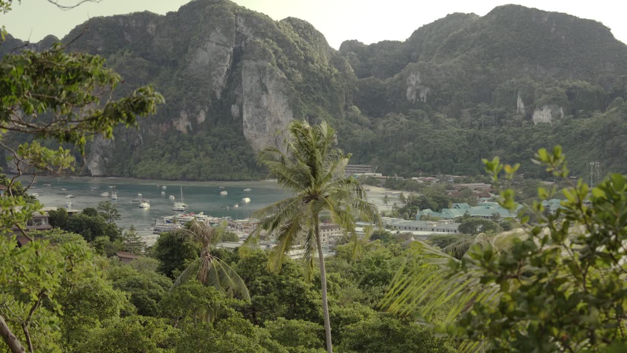 Vista idilliaca dell'isola di Phi Phi incorniciata da palme durante il tramonto in Thailandia