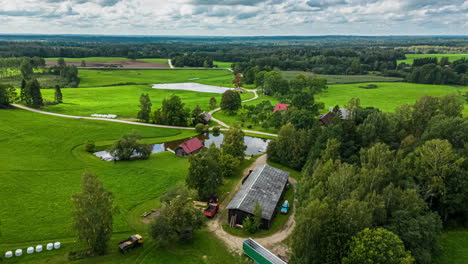 Kleine-Wohngemeinschaft-Rund-Um-Den-Teich,-Der-Bewölkten-Himmel-Reflektiert,-Hyperlapse-Aus-Der-Luft