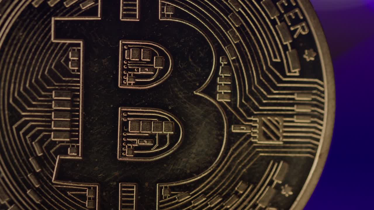 Bitcoin spinning around into warm light.  Close up.  4K Bokeh balls in the background.