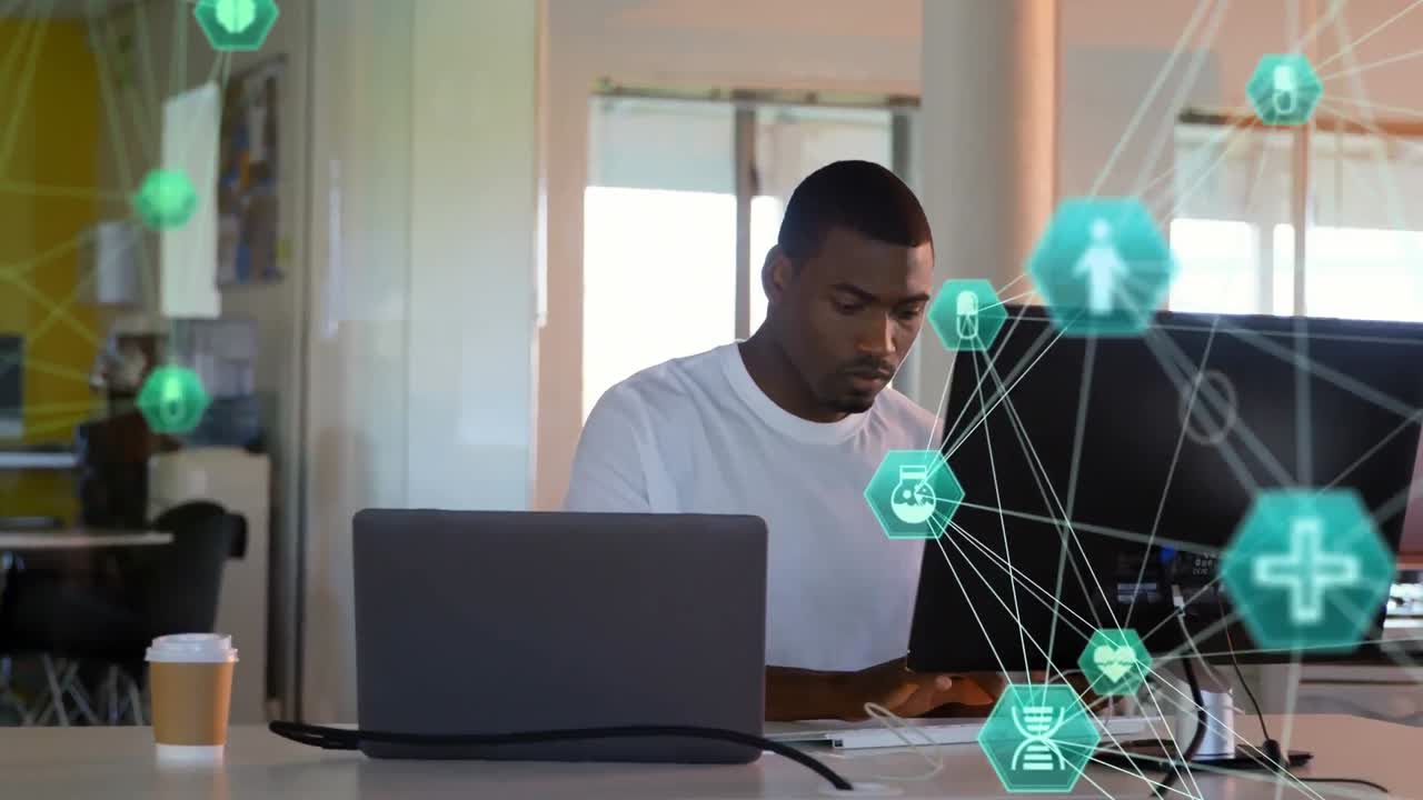 Animation of globes of digital icons spinning against african american man using computer at office