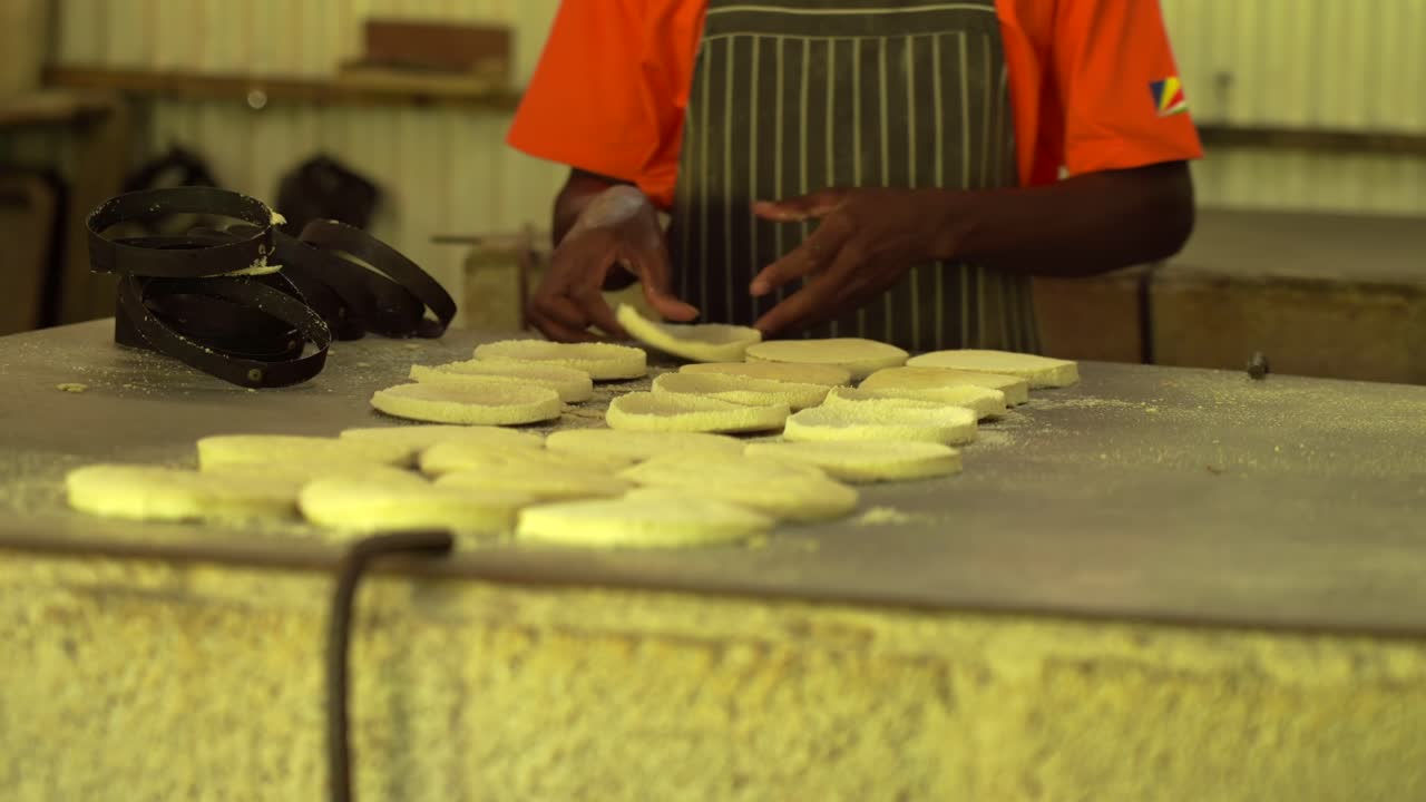 Man removing rings around galettes and flipping sides of the baking cassava galette on hot grill by hands, Mahe, Seychelles 30fps