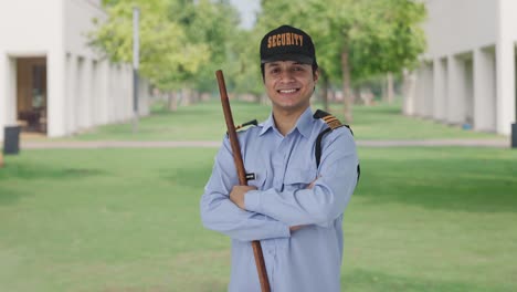 retrato de un feliz guardia de seguridad indio de pie con las manos cruzadas