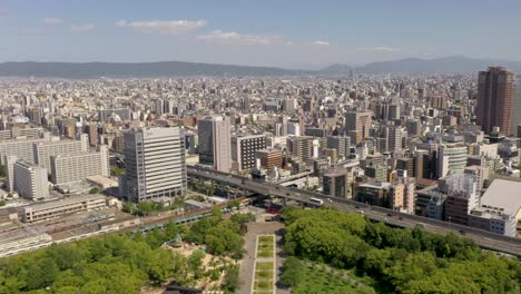 Aerial-of-Osaka-Castle-Park-Fountain-with-skyline,-skyscraper,-and-city-in-Osaka,-Japan