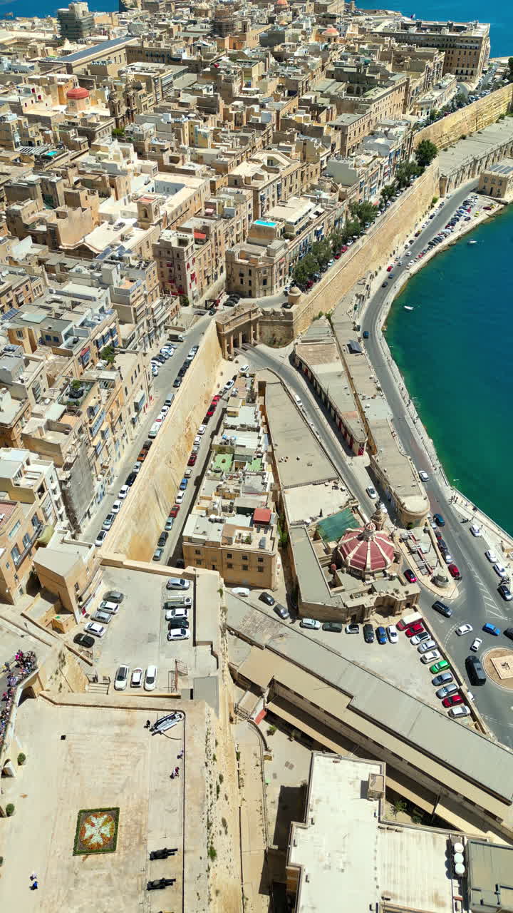 Aerial drone view of the walled city of Valletta, Malta, surrounded by the Mediterranean sea in daylight. Vertical