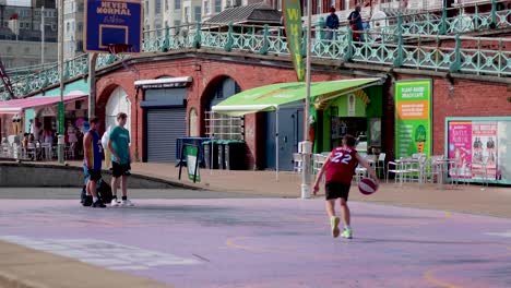 people playing basketball near brighton seafront