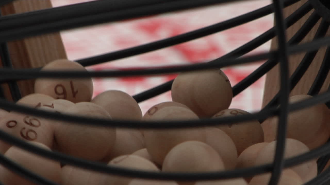 빙고 카드 앞에서 회전하는 빙고 공 케이지