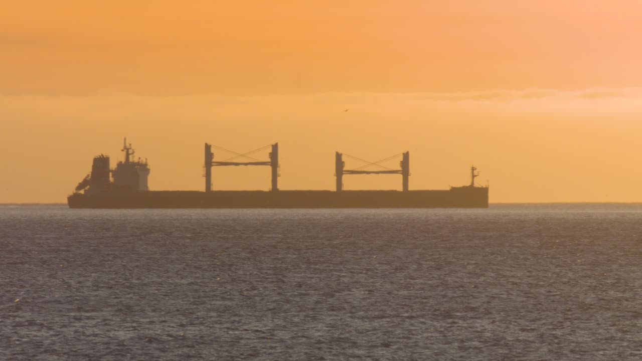 일몰 실루엣에 화물선