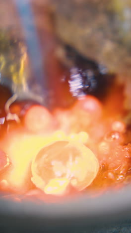 cu: melting old gold accessories in special cup with hot burner on table with asbestos sheet in jewelry workshop closeup