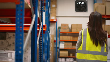 Team-Leader-With-Digital-Tablet-In-Warehouse-Training-Female-Intern-Standing-By-Shelves