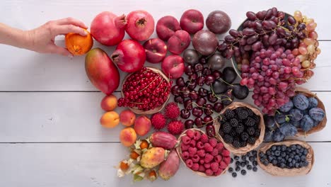 decorating a variety of colorful fruits on a white wooden table. colourful thanksgiving or harvest concept.