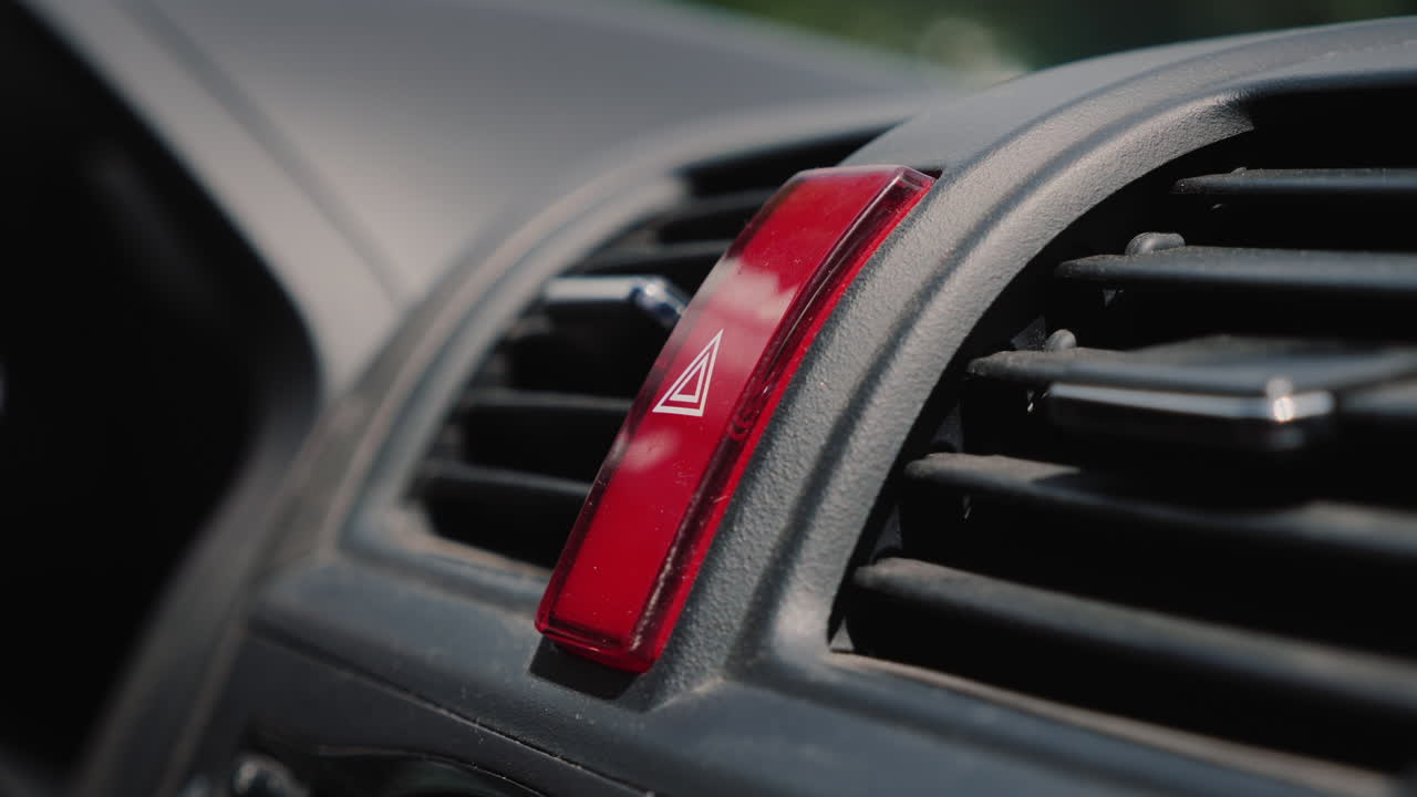 el dedo presiona el botón rojo de emergencia en el coche