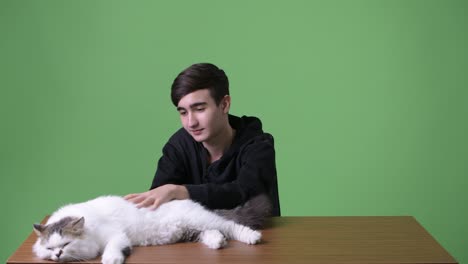 young handsome iranian teenage boy against green background