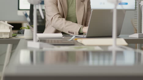 mujer que trabaja usando una computadora portátil sentada en el escritorio en la oficina 1