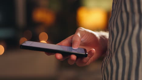 mano usando un teléfono inteligente por la noche