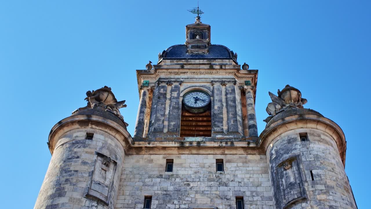Grosse Horloge clock tower, stone facade, turrets, La Rochelle, France. Tilt-up, low-angle pov