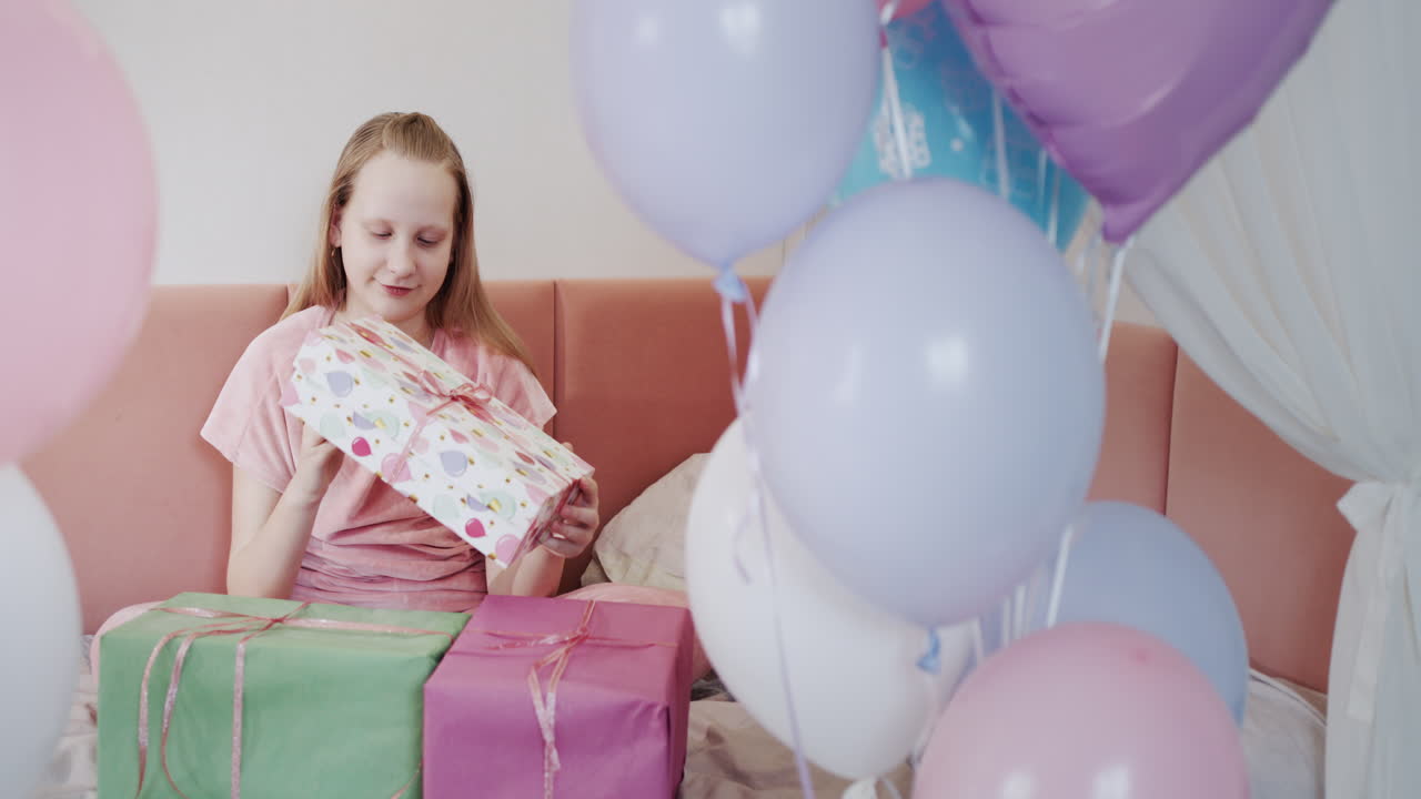 la niña recibió regalos de cumpleaños, su habitación está decorada con globos