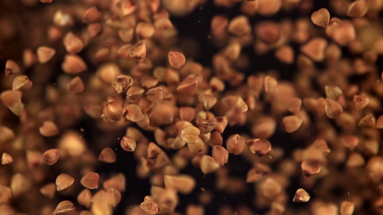 Buckwheat Groats Falling in Slow Motion on Black Background