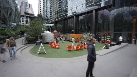 timelapse of families gathering at a recreational area next to the spheres at amazon in seattle. the lively space offers activities and seating, surrounded by modern architecture and greenery.