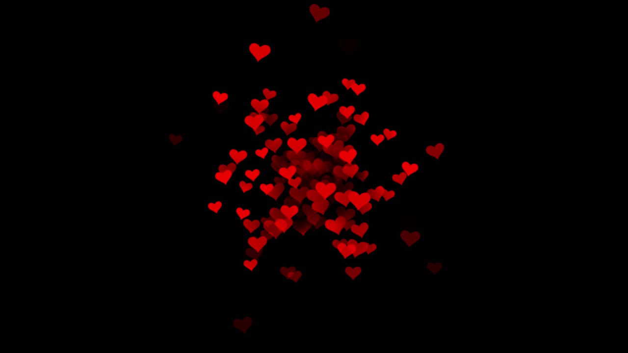 Esplosione animata di particelle a forma di cuore rosso su sfondo nero