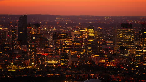 Cityscape-view-from-above-of-the-Paris-skyline,-illuminated-during-a-bright-orange-sunset,-France