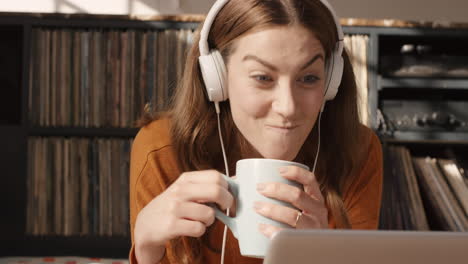 Beautiful-woman-at-home-talking-to-friend-on-internet-app-on-laptop-lying-on-floor-relaxed