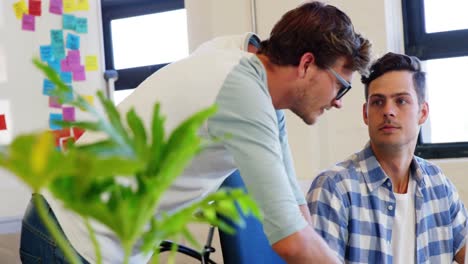 Male-executives-discussing-over-laptop