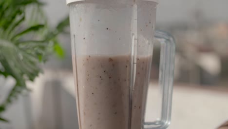 blender making fresh fruit smoothie in the kitchen