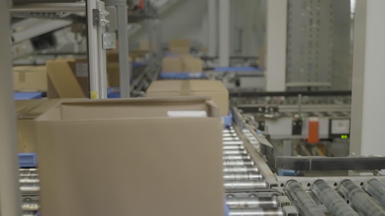 las cintas transportadoras mueven cajas de cartón marrón a través de la línea de embalaje de una fábrica moderna