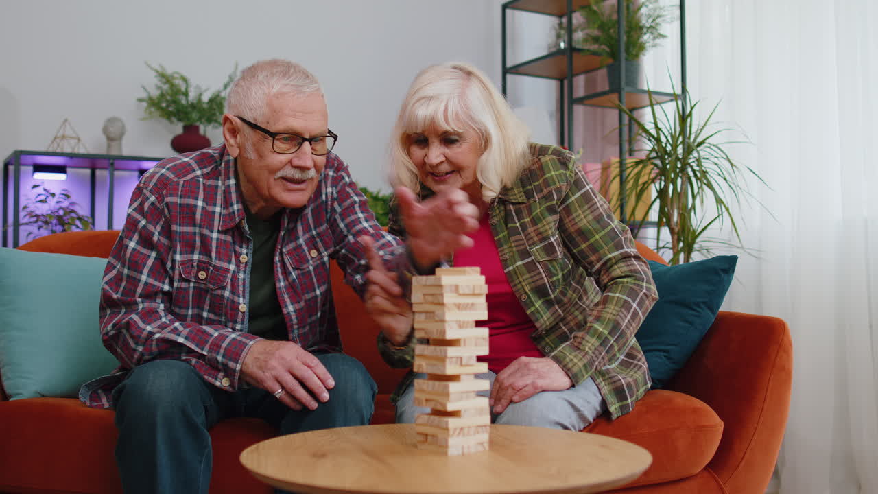 ancianos abuelos hombre mujer jugando en bloques torre de madera construir juego de mesa en la mesa en casa